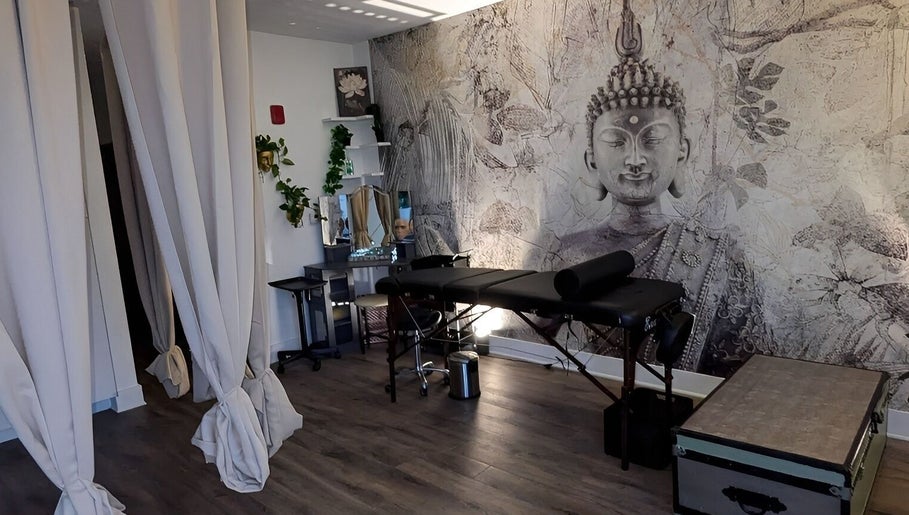 Tranquil Touch Spa massage room with serene decor in Atlanta, Georgia, US, featuring a Buddha mural and calming ambiance.