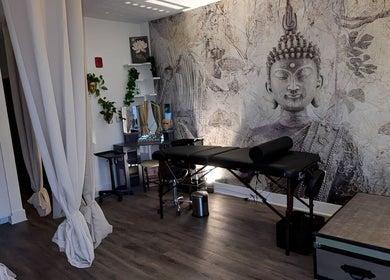 Tranquil Touch Spa massage room with serene decor in Atlanta, Georgia, US, featuring a Buddha mural and calming ambiance.