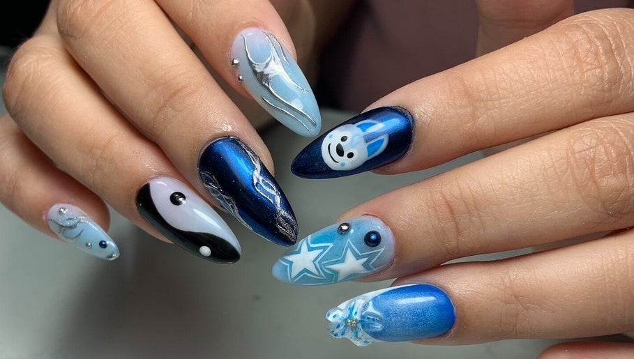 Diseño de uñas azul creativo en Nailss by Carlota, Maracay, Aragua, VE, con detalles de estrellas y líneas plateadas.