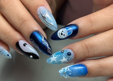 Diseño de uñas azul creativo en Nailss by Carlota, Maracay, Aragua, VE, con detalles de estrellas y líneas plateadas.