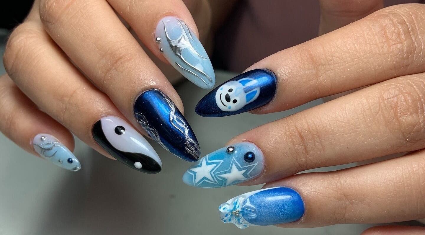 Arte de uñas llamativo en Nailss by Carlota, Maracay, Aragua, VE. Diseño azul con figuras y detalles brillantes.