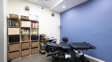 Therapy room at Fixinhumans, New York, New York, US, featuring a treatment table and shelves for wellness.