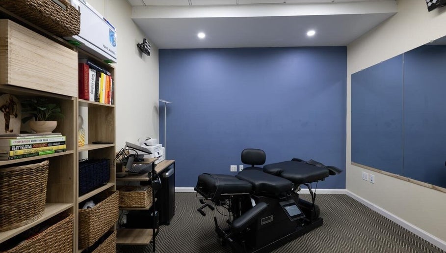 Modern wellness room at Fixinhumans Manhattan in New York, New York, US, featuring therapy bed and storage shelves.