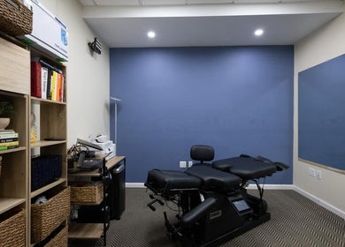 Modern wellness room at Fixinhumans Manhattan in New York, New York, US, featuring therapy bed and storage shelves.