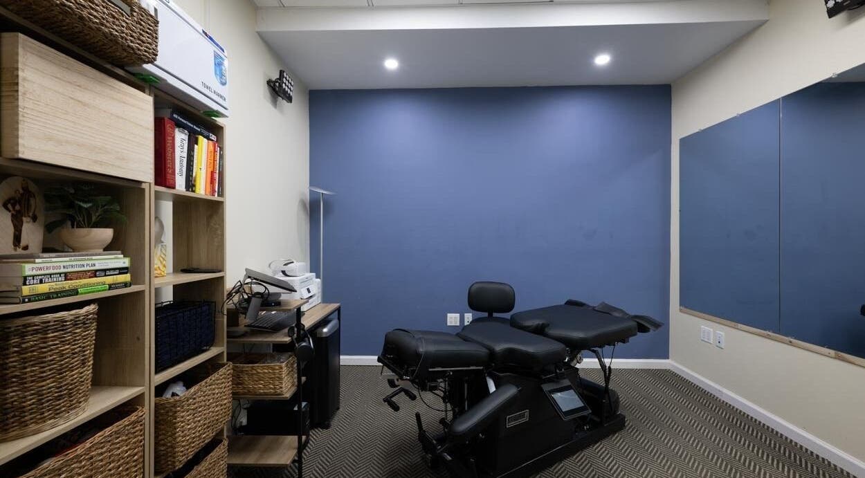 Modern wellness room at Fixinhumans Manhattan in New York, New York, US, featuring therapy bed and storage shelves.