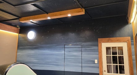 Peaceful interior of Dharma River ZenFloat Spa in Daphne, Alabama, US, featuring starlit ceiling and calming decor.