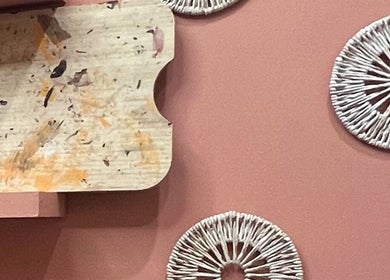 Artistic decor with circular patterns on a peach wall at The Vibe Cove, Tempe, Arizona, US.