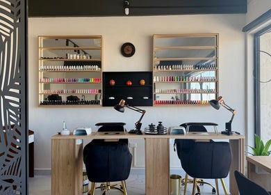 Interior moderno de DisisSpa&Nails en Saltillo, Coahuila De Zaragoza, MX, con estantes de esmaltes vibrantes.