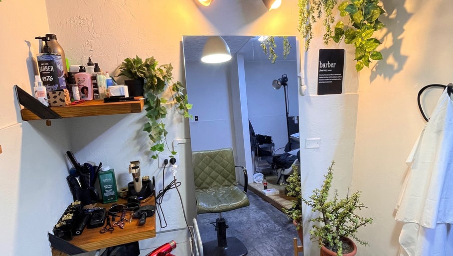 Interior acogedor de Nexo Hair Studio en San Isidro, Provincia De Lima, PE, con plantas y herramientas profesionales.