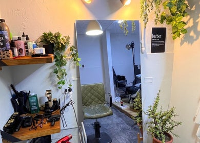 Interior acogedor de Nexo Hair Studio en San Isidro, Provincia De Lima, PE, con plantas y herramientas profesionales.