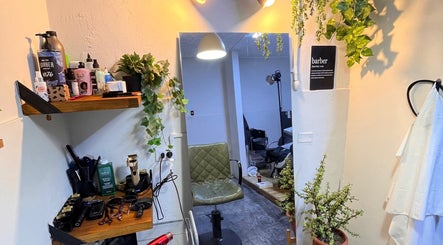 Interior acogedor de Nexo Hair Studio en San Isidro, Provincia De Lima, PE, con plantas y herramientas profesionales.