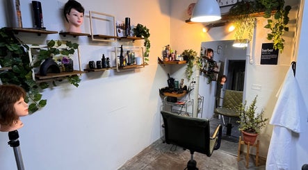 Interior de Nexo Hair Studio en San Isidro, Provincia De Lima, PE, con decoración de plantas e instrumentos de estilismo.