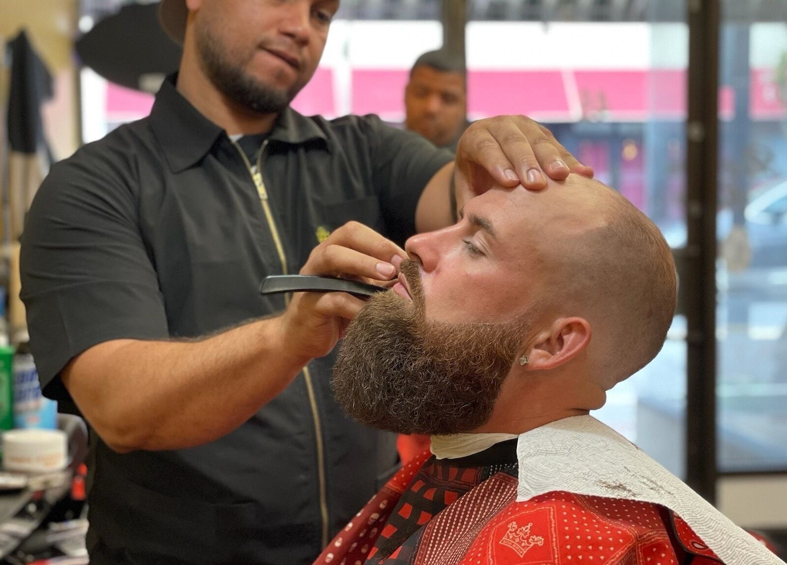 Luisthebarber-evolutionpatchogue barber skillfully trimming beard at Patchogue, New York, US salon.
