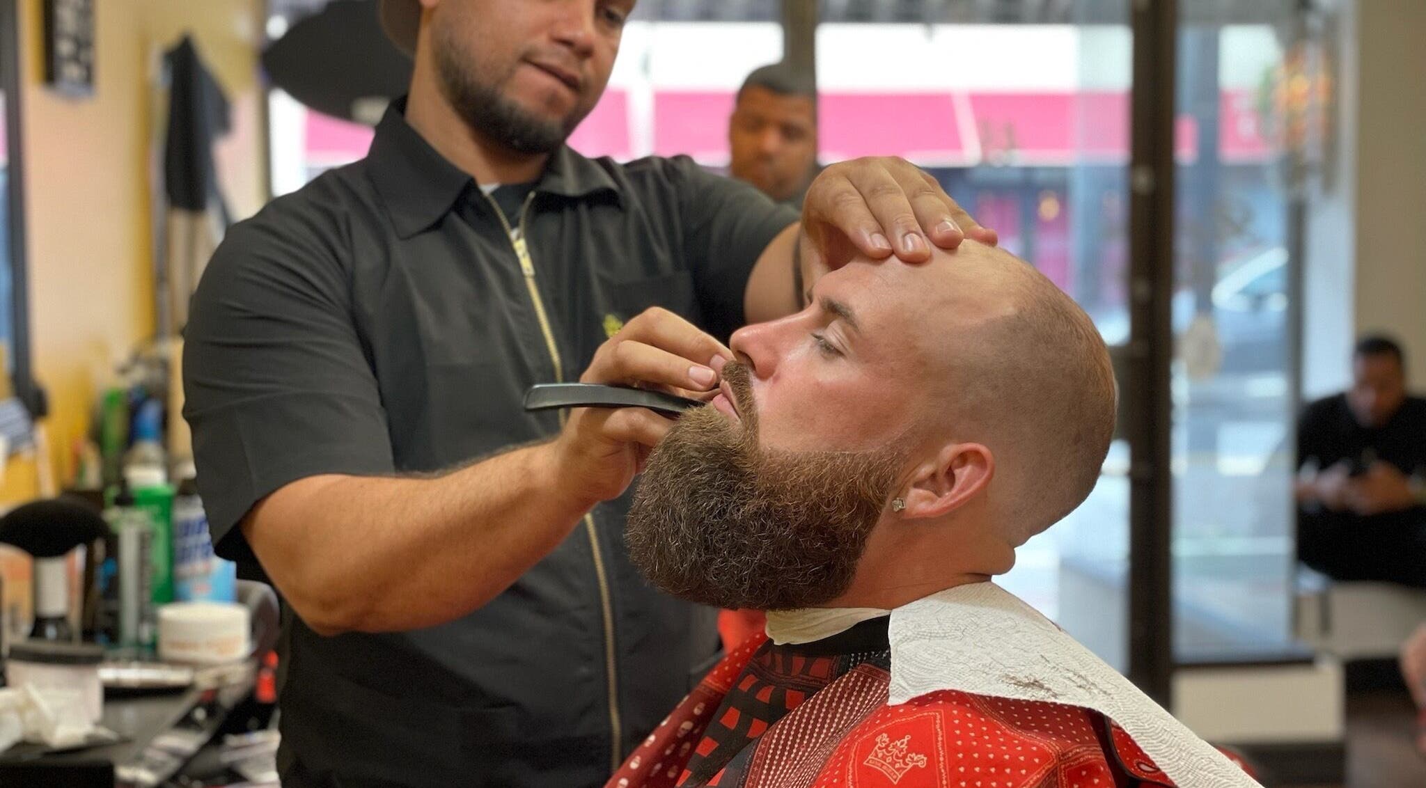 Luisthebarber-evolutionpatchogue barber skillfully trimming beard at Patchogue, New York, US salon.