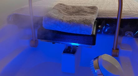 Steam room at Peaceful Whispers The Head & Soul Spa in Tooele, Utah, US, featuring a cozy towel and serene lighting.