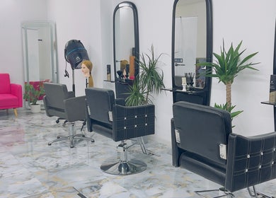 Modern salon interior at Diddy's Beauty & Wellness, London, England, GB with sleek black chairs and mirrors.