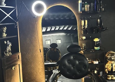 Interior de London Barber’s en Tijuana, Baja California, MX con silla de cuero y espejo iluminado.