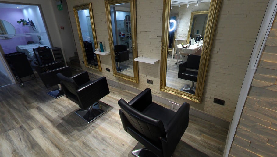 Elegant styling area at Eleven Eleven Salon, Stirling, Scotland, GB with sleek black chairs and gold mirrors.