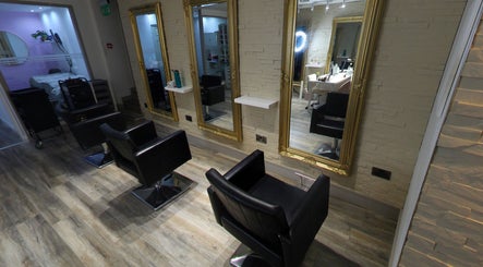 Elegant styling area at Eleven Eleven Salon, Stirling, Scotland, GB with sleek black chairs and gold mirrors.