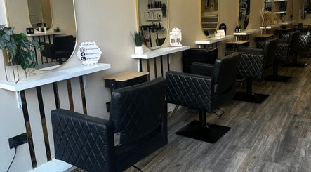 Elegant salon interior at Eleven Eleven Salon, Stirling, Scotland, GB with black quilted chairs and mirrors.