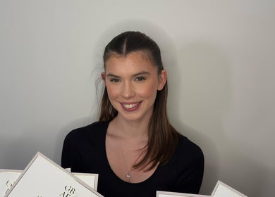 Smiling person with certificates at Ell Glow, Bury, England, GB, exemplifying excellence in beauty services.