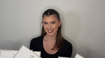 Smiling person with certificates at Ell Glow, Bury, England, GB, exemplifying excellence in beauty services.
