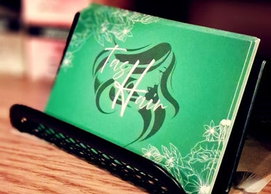 TasHair business card in a holder, Blacon, England, GB. Elegant design with floral accents.