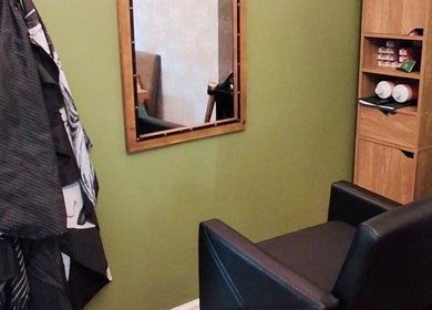 TasHair salon seating area in Blacon, England, GB featuring a mirror and storage shelves.