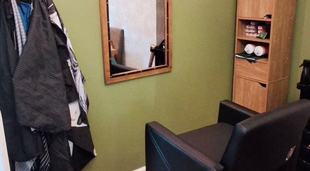 TasHair salon seating area in Blacon, England, GB featuring a mirror and storage shelves.