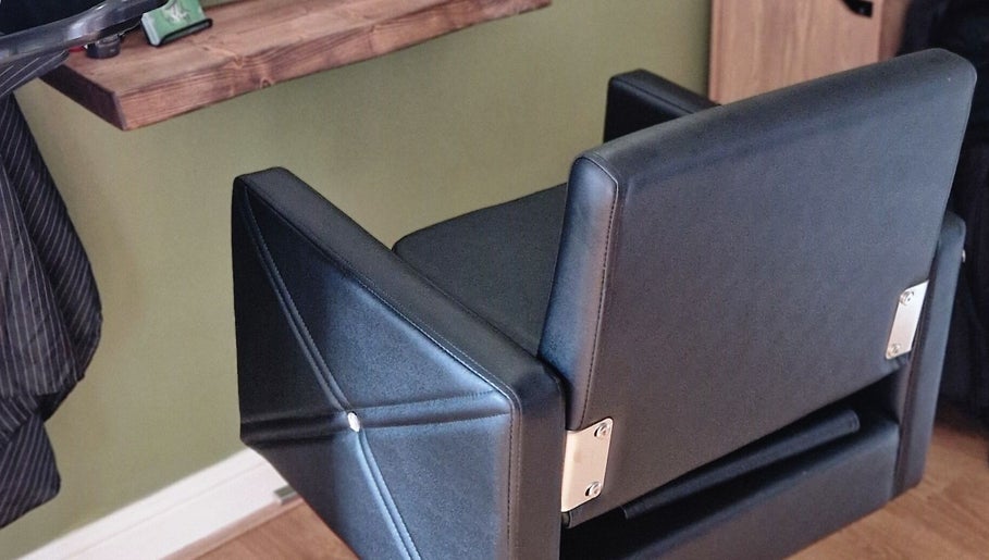 Modern black salon chair at TasHair in Blacon, England, GB, enhancing the chic interior.