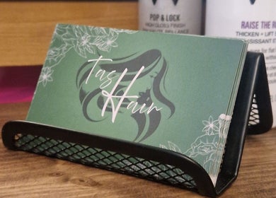 TasHair salon business cards in Blacon, England, GB, displayed on a wooden surface.