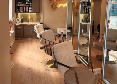 Interior of Laurencoyhair salon in Leicester, England, GB with sleek chairs and large mirrors.