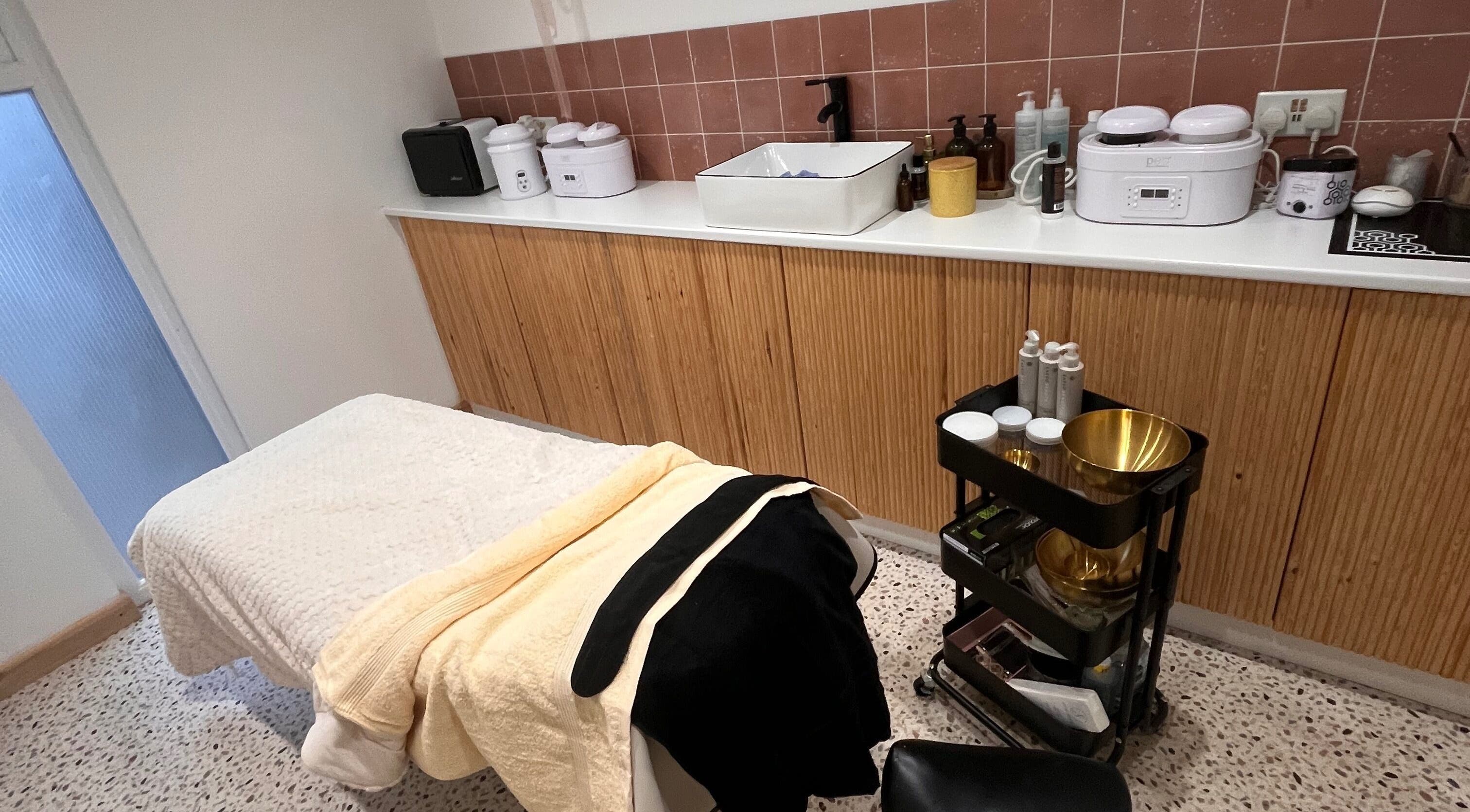 Relaxing treatment room at Glō by Kendra, Bristol, England, GB, featuring a massage table and skincare products.