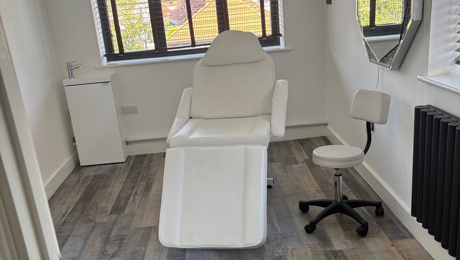 Clean, minimalist beauty treatment room at Beauty by Rhianne, Norwich, England, GB with white chair and decor.