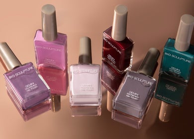 Bio Sculpture nail polishes in vibrant colors on reflective surface, London, England, GB.