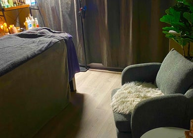 Cozy treatment room at Hillside Remedial and Spa in Melbourne, Victoria, AU, featuring massage table and armchair.