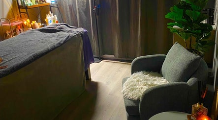 Cozy treatment room at Hillside Remedial and Spa in Melbourne, Victoria, AU, featuring massage table and armchair.