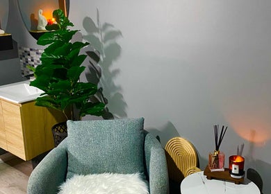 Calm spa corner at Hillside Remedial and Spa, Melbourne, Victoria, AU with chair, candles, and plant.