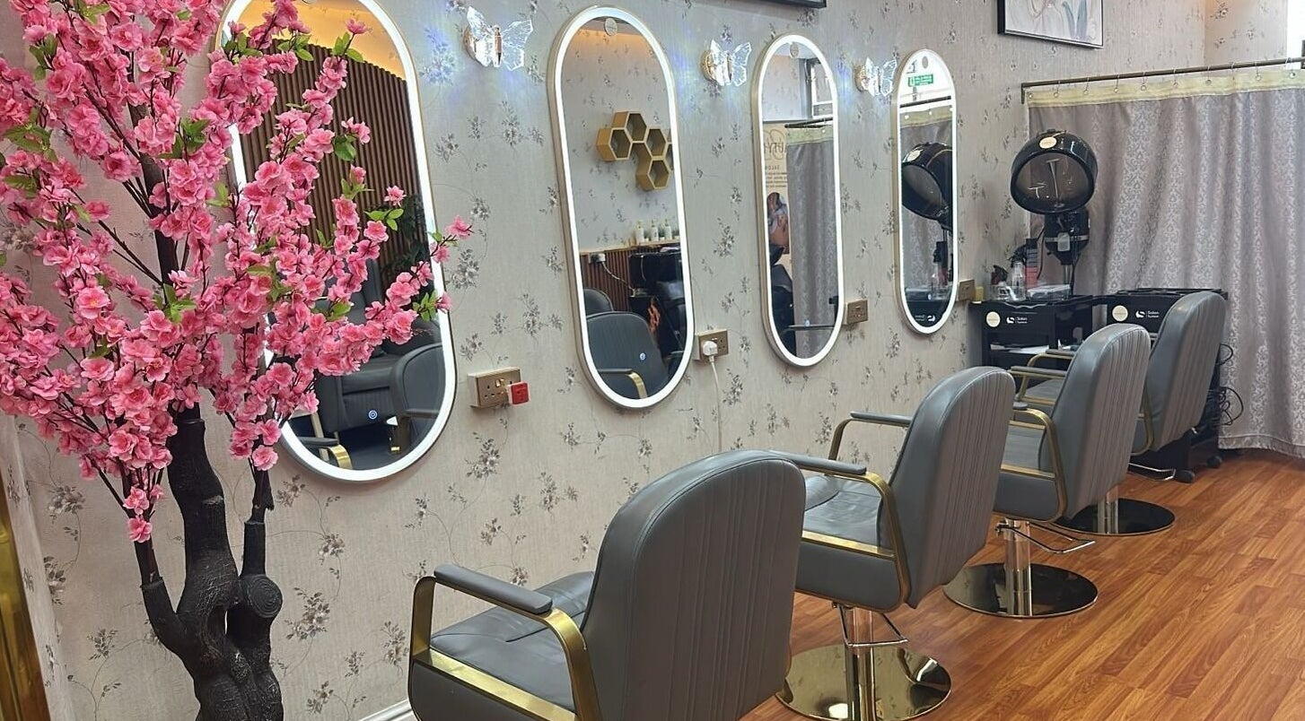 Elegant salon interior at Beauty Bond Salon - Home Service, Riyadh, Riyadh Province, SA, featuring mirrors and pink blossoms.