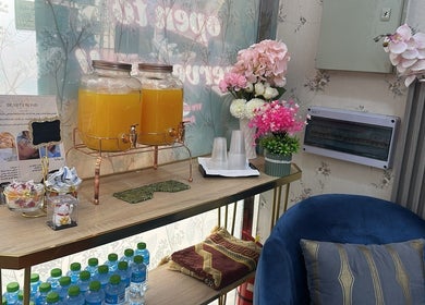 Cozy refreshment corner at Beauty Bond Salon in Riyadh, Riyadh Province, SA, featuring drinks and flowers.