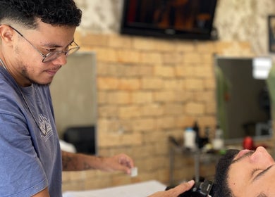 Barbeiro realizando corte de cabelo preciso na Kauã Ripardo Barbershop, Ceará, Ceará, BR.