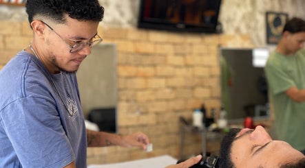 Barbeiro realizando corte de cabelo preciso na Kauã Ripardo Barbershop, Ceará, Ceará, BR.