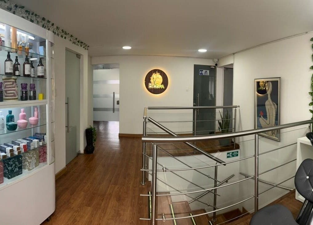 Interior de BIOSPA en Bogotá, D.C., mostrando una escalera elegante y productos de belleza.