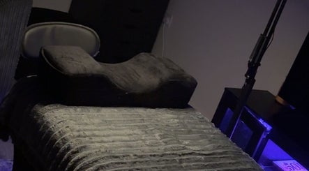 Massage chair in dimly lit relaxation area at BC Beauty Bar, Birchwood, England, GB.