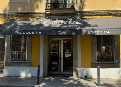 Entrada de ONDA Hair & Beauty Salon en Barcelona, Catalunya, ES con toldo negro y paredes amarillas.