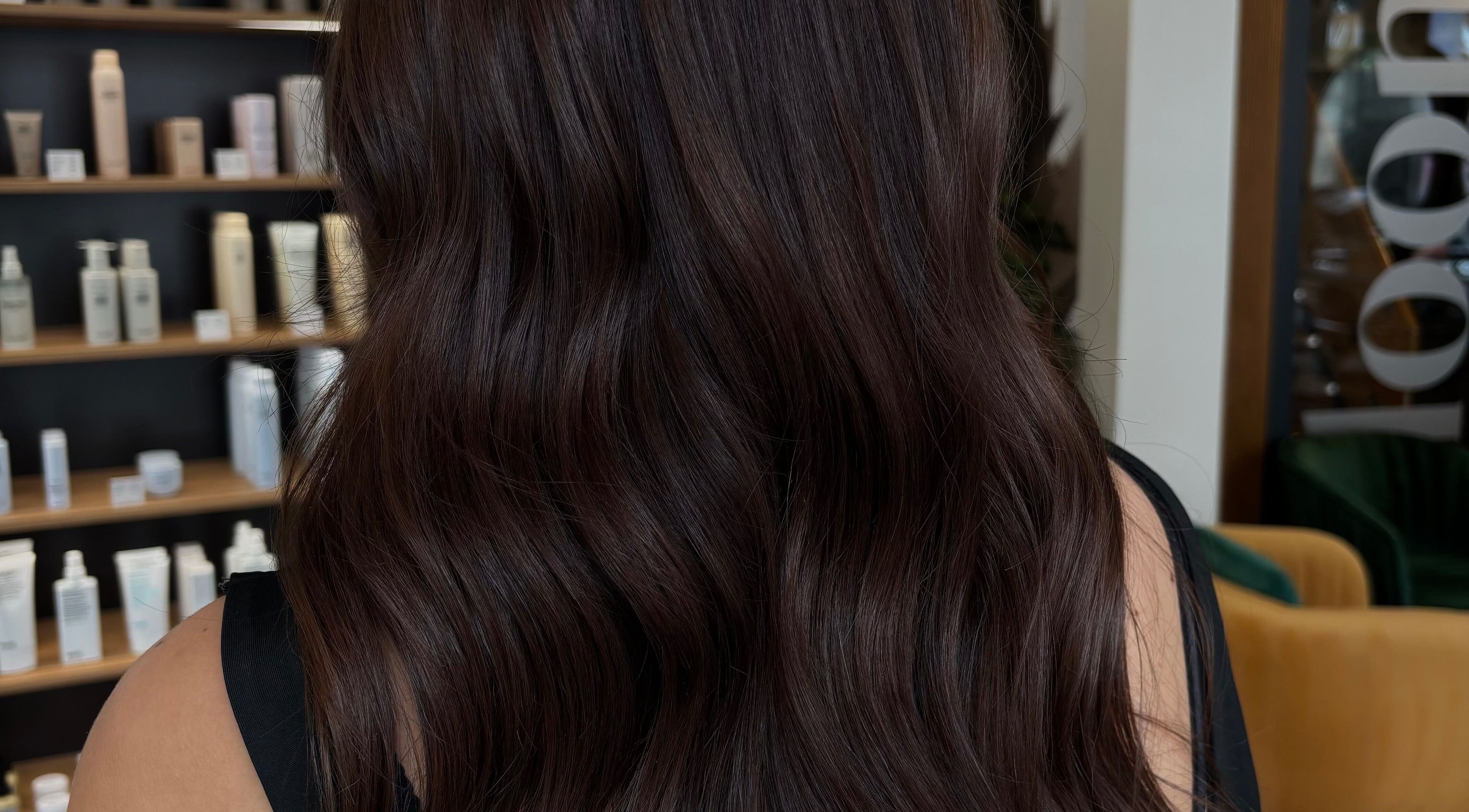 Lustrous dark hair with wavy texture at Livedinbyerinx, Aberdeen, Scotland, GB. Elegant salon environment.