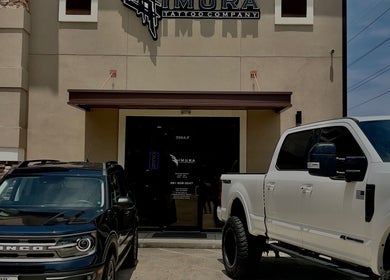 Front view of Kimura Tattoo Company, Conroe, Texas with parked cars in front.