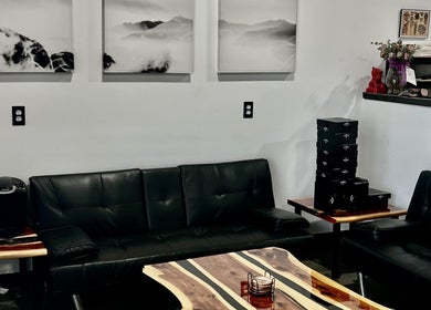 Kimura tattoo company in Conroe, Texas, US features a cozy lounge with black leather sofas and a stylish coffee table.