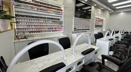 Sleek manicure stations at Maison Gloss Nail Lounge in Hamilton, Ontario, CA, showcasing a vast array of nail polishes.