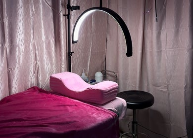Cozy beauty station at Nyla Beauty & Fashion, Paramaribo, SR with pink decor and plush seating.